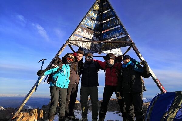 group of people at the peak of mount toubkal