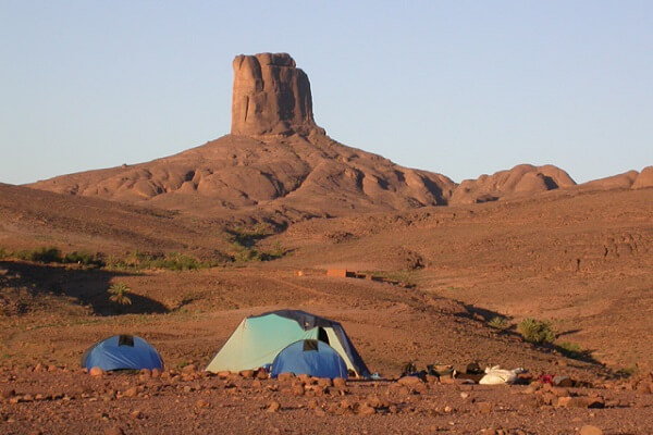 tents in mountains with high rock