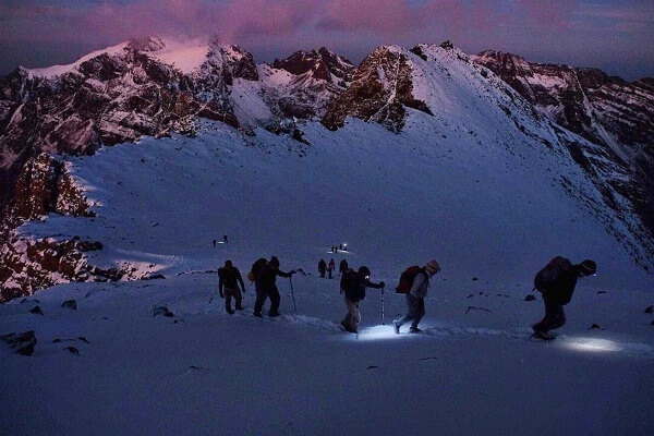 people climbing a mountain in early morning