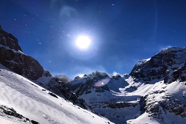 mountain covredwith snow and sun shines