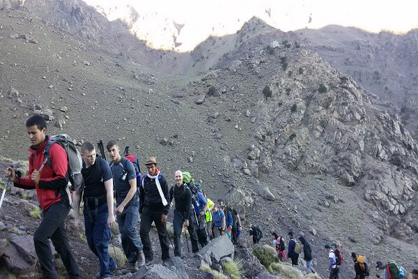 group of people walking in the mountains