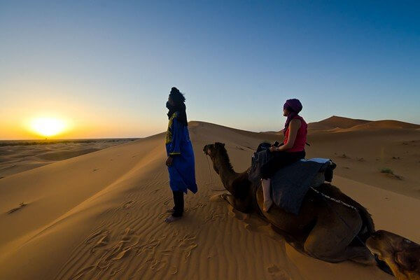 setting on camel looking at sunset