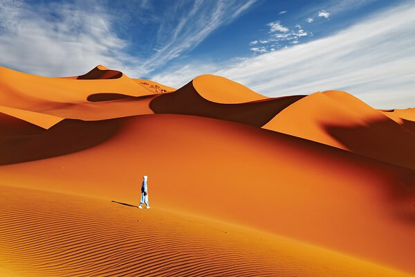 a solo man in midle of sund dunes in morocco