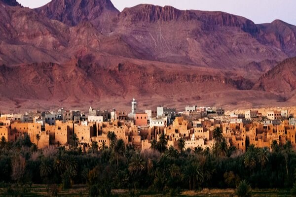 palmtrees and mude buildings followed by mountains